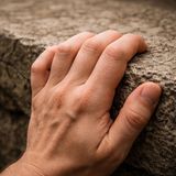 Fingers tighten on stone